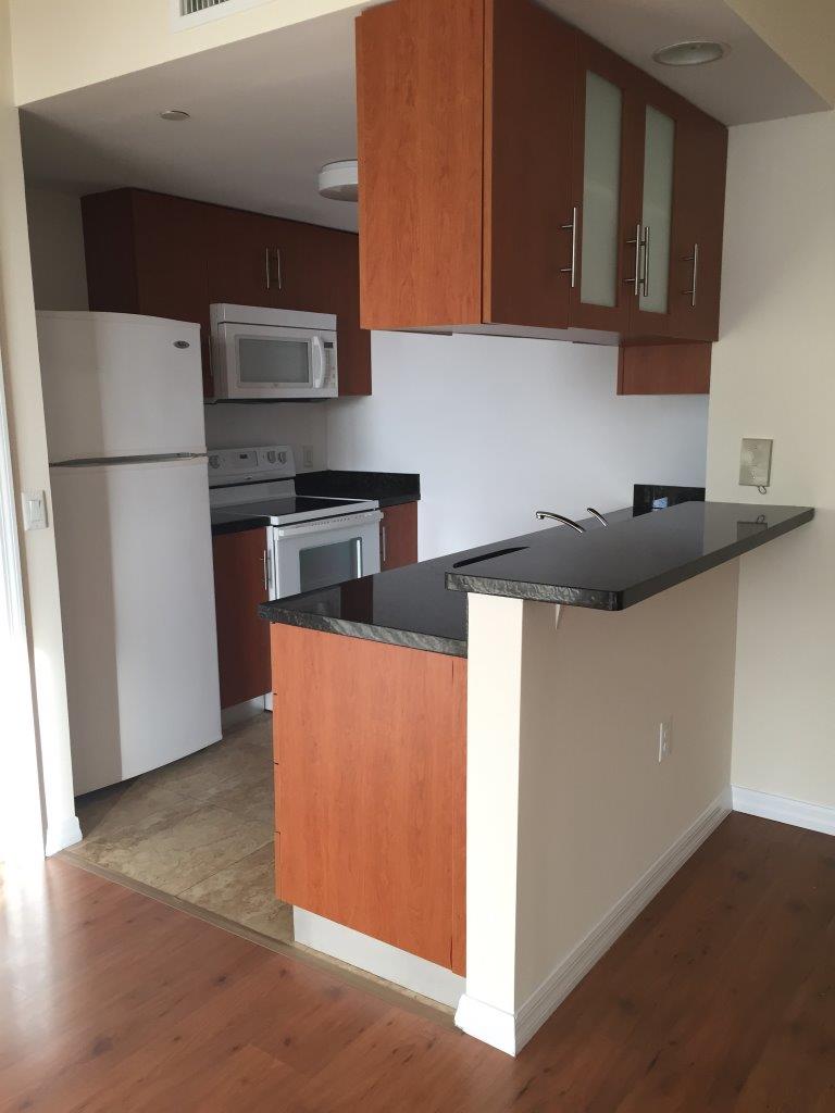 Kitchen with granite breakfast bar and wood cabinets