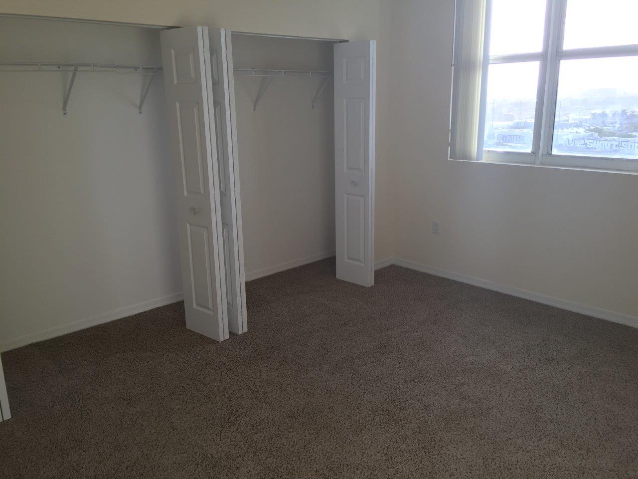 Bedroom with closet and city window