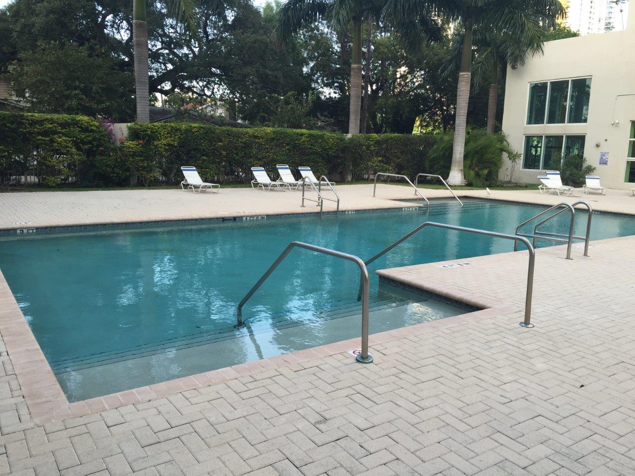 Pool deck with lounge chairs and palms